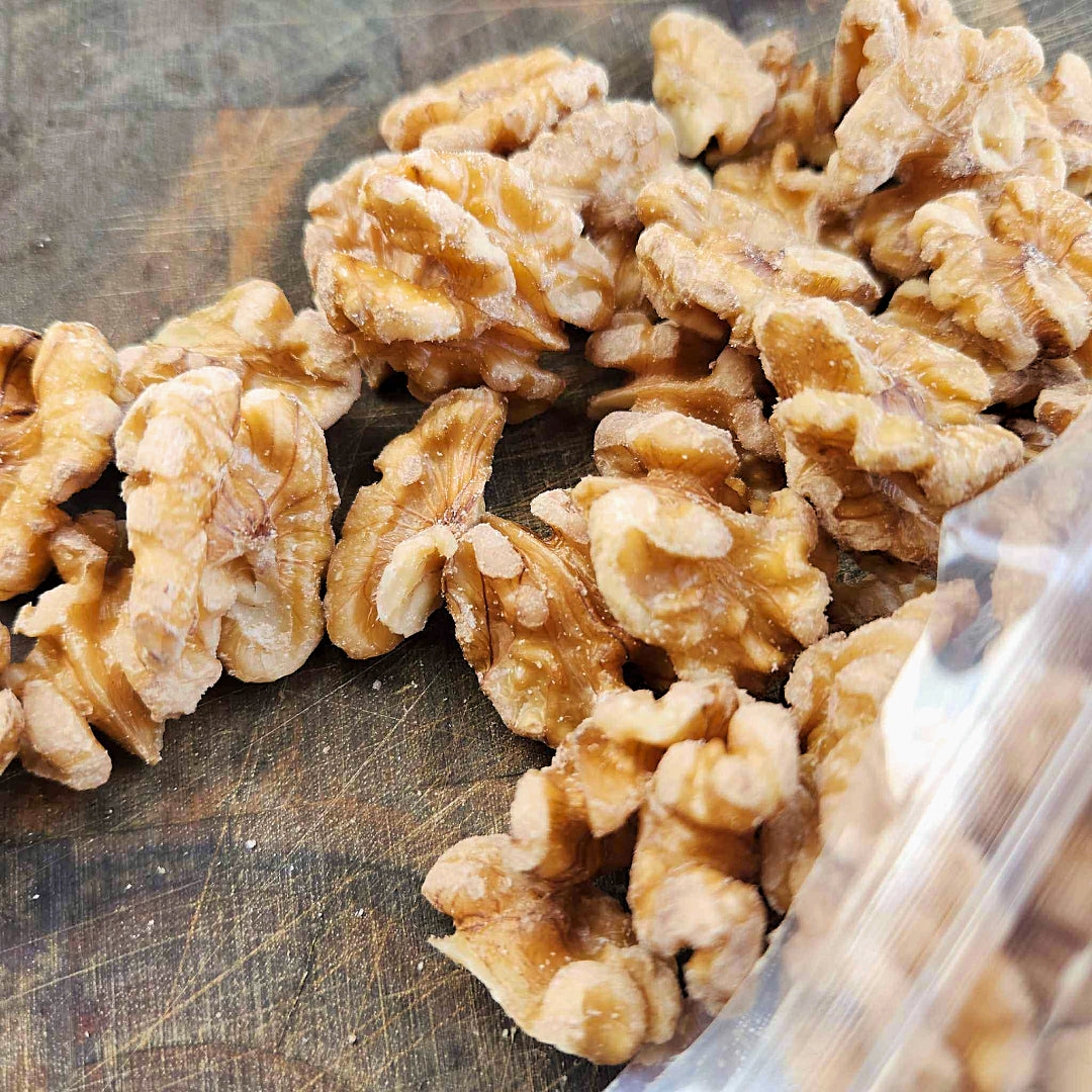 Organic fresh sprouted walnuts spread across a butcher block for snacks.